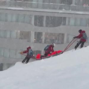 Preview thumbnail for Urgent Rescue on the Slopes in Niseko, Hokkaido, Japan. A Ski patrol was transporting an injured skier downhill on a stretcher while performing CPR.